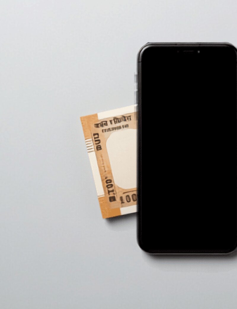 A smartphone beside Indian rupee banknotes